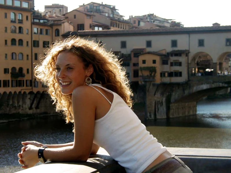 the girl is posing for the camera outside by the water