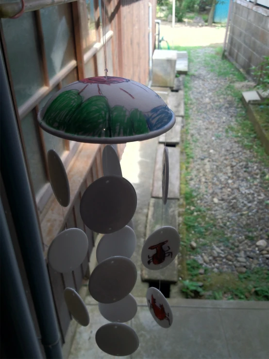 some green and white dishes are hanging from a string