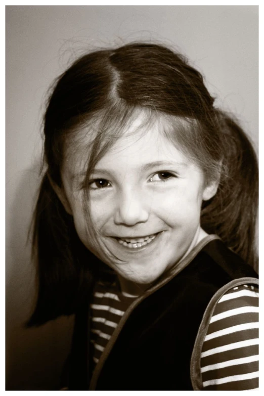 a smiling girl in black and white pograph with her ponytail