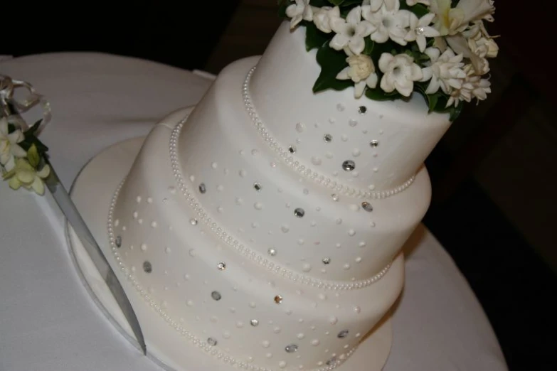 the tiered cake has flowers and beads on it