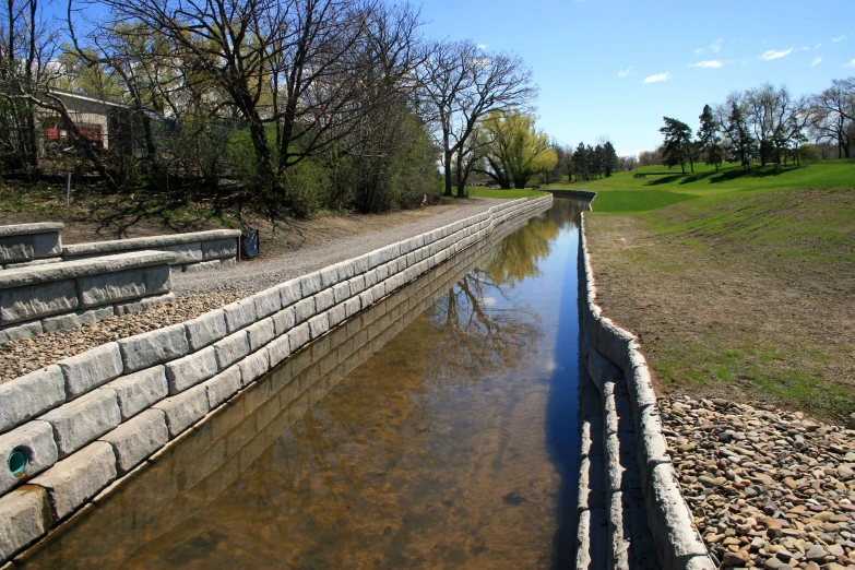 a waterway near the grassy field with steps leading down