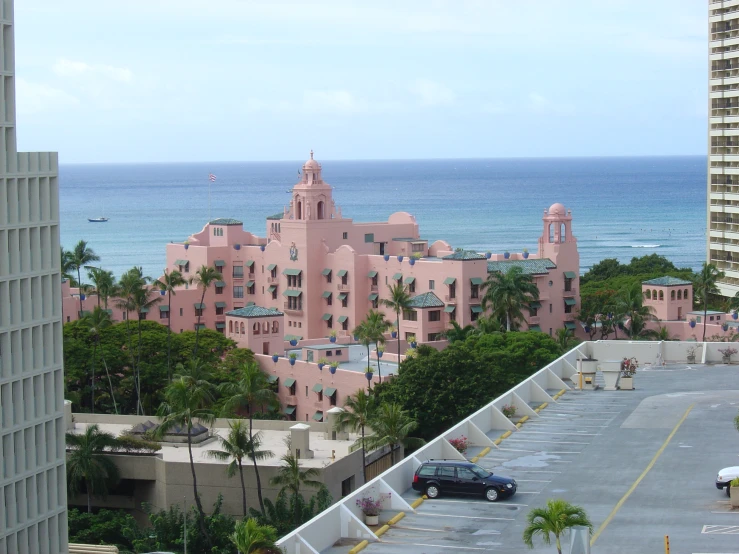 a large building next to an ocean with pink color