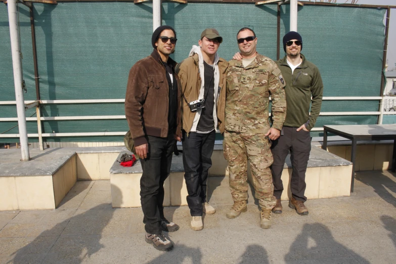 a group of four people in military uniforms posing for the camera