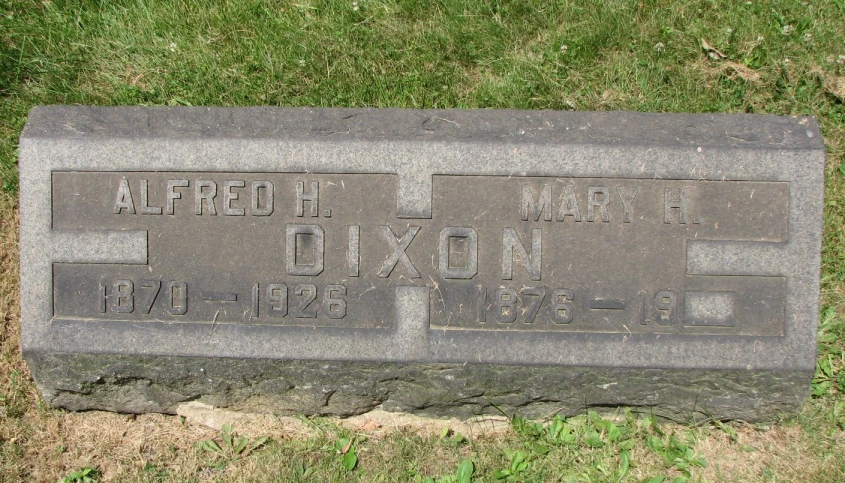 a headstone with a cross, two names and a date