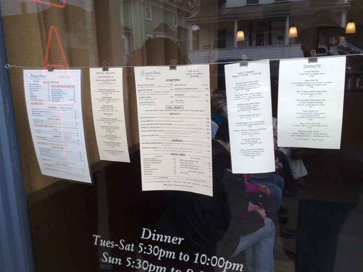 a number of white paper stuck to the side of a glass door