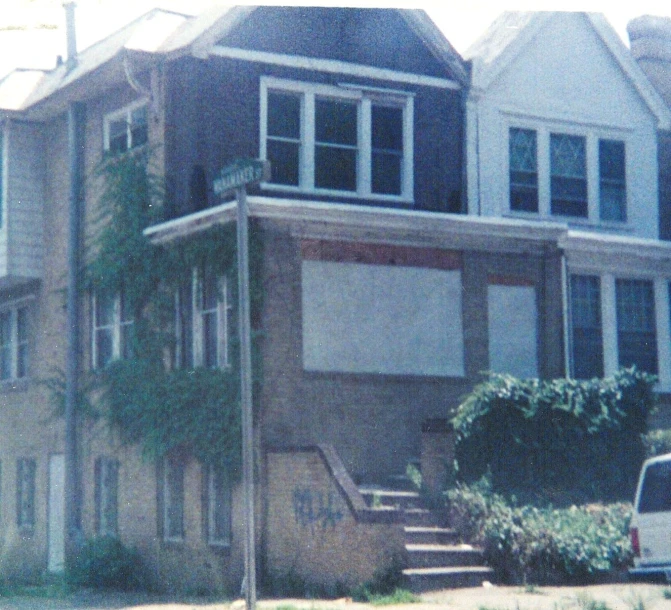 a car parked next to two story houses on a street