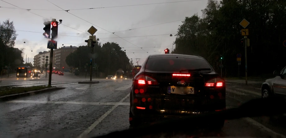 a car stopped at a stop light on a rainy day