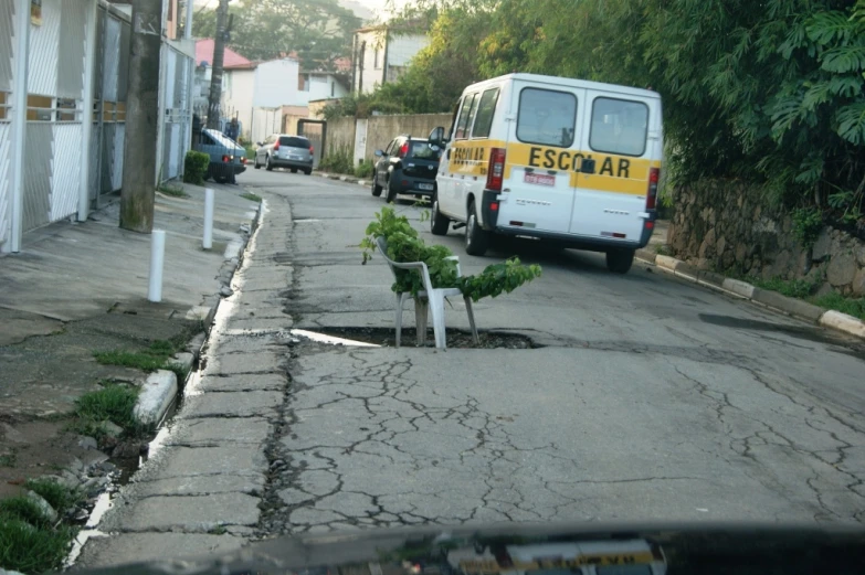 a van is parked next to the tree on the street