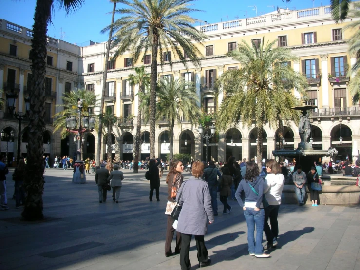 people are walking around in front of a large building