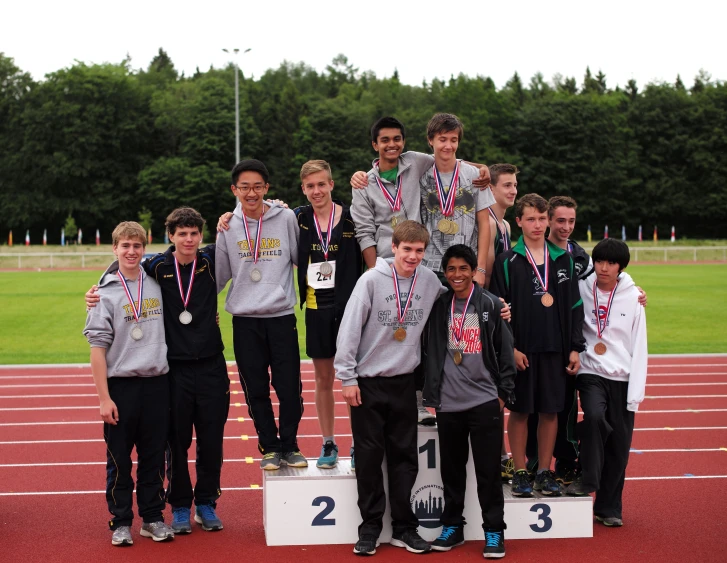 a group of boys posing for a po on a track