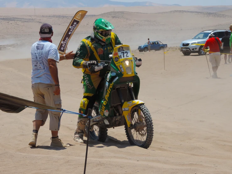 a motor bike rider is standing by himself