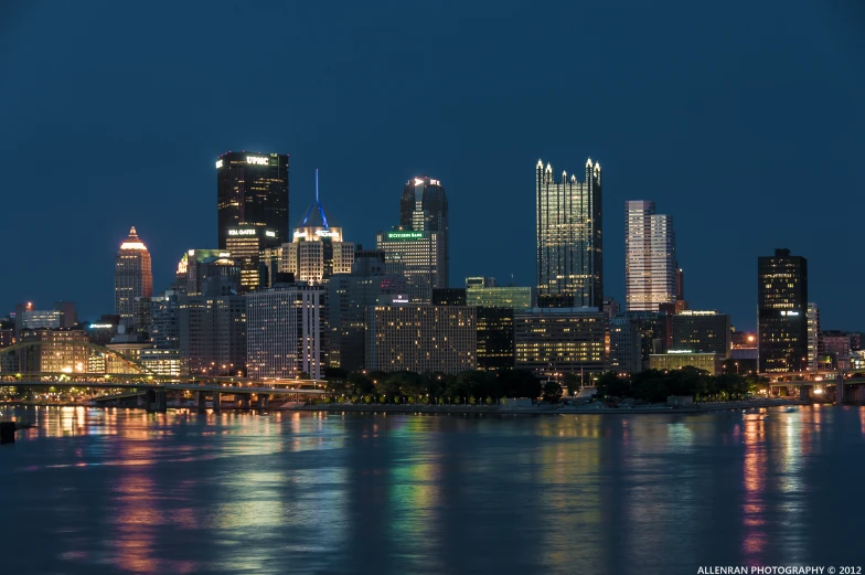 a city skyline is shown with its lights reflected on the water