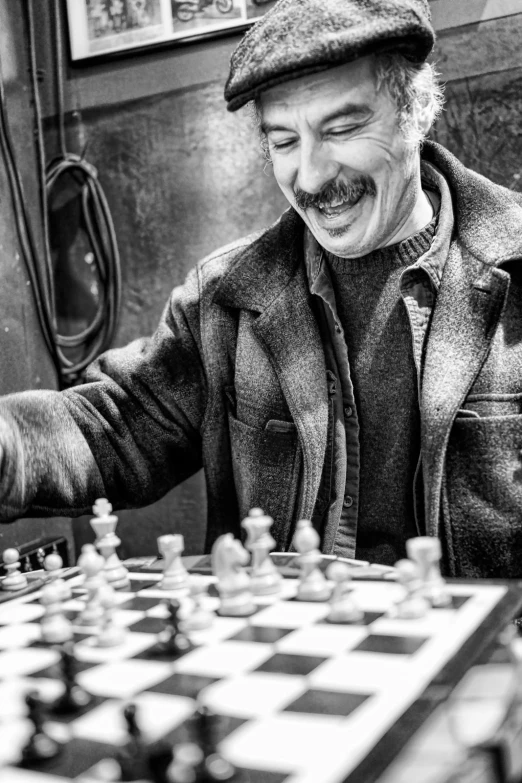 black and white pograph of man playing chess