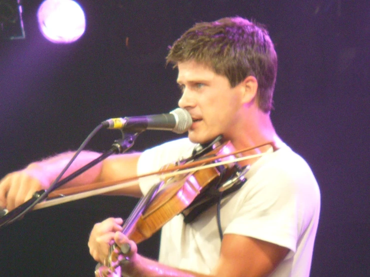 a man playing the violin on stage during a show