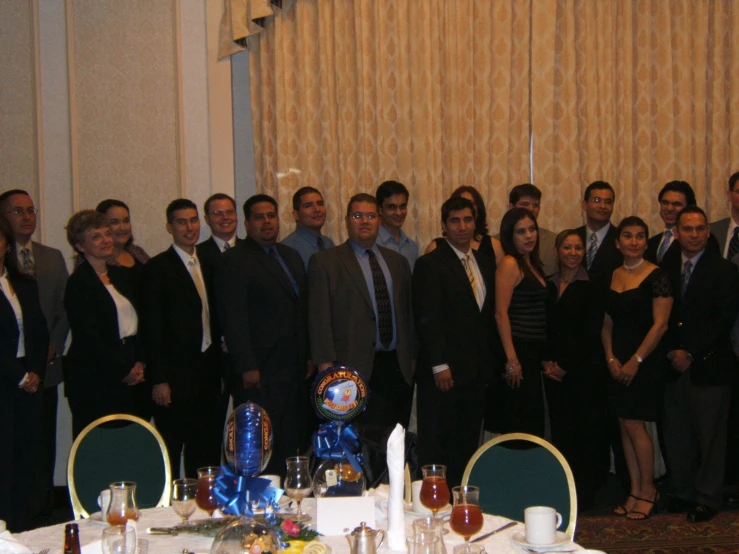 a group of people standing around a table with glasses and silverware