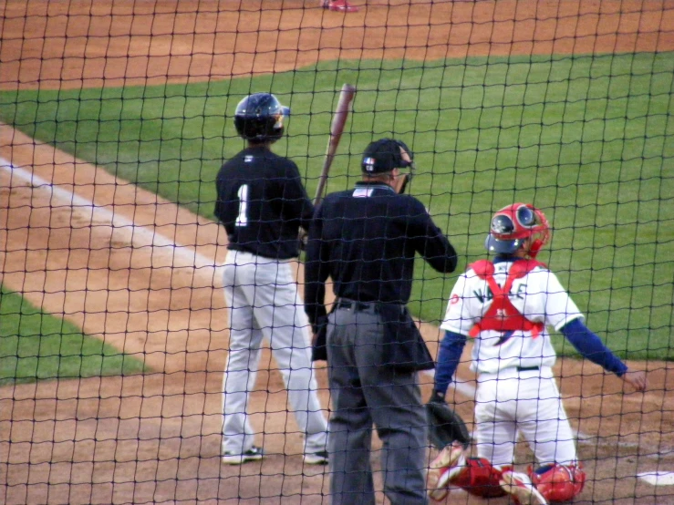 the umpire holds up a baseball bat and sticks