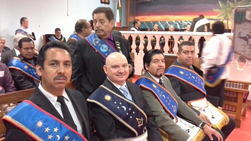 several men in suits with flags sitting next to each other