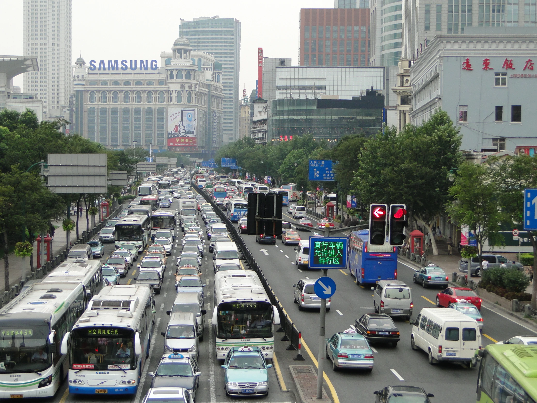 a city street full of traffic surrounded by tall buildings