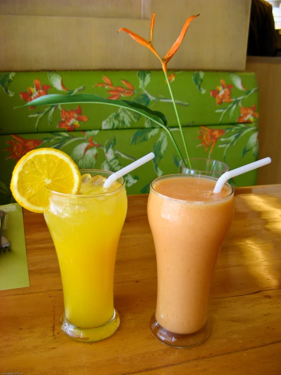 two glasses with orange and yellow colored juice