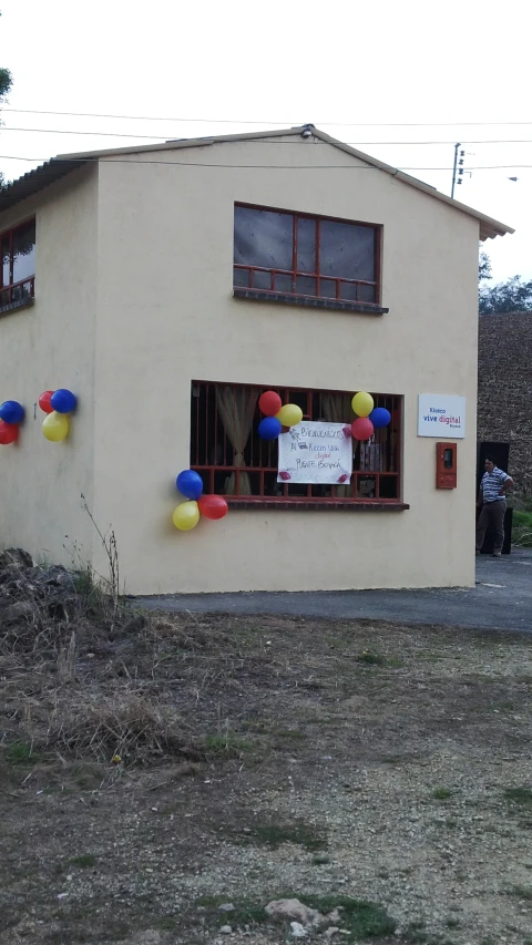 a house with balloons on it and a sign in front of the window