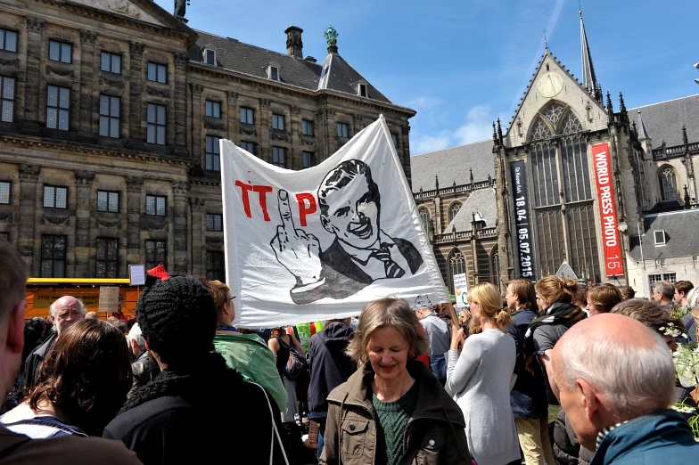 a woman holding a political protest sign in a crowd