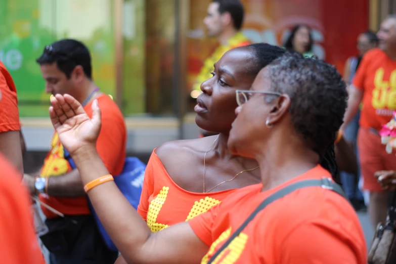 people wearing orange shirts holding hands in front of each other