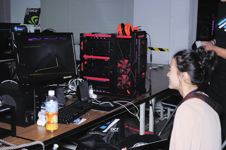 a person sitting at a desk in front of computers