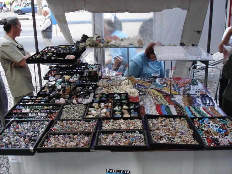 an array of bead necklaces on display under a tent