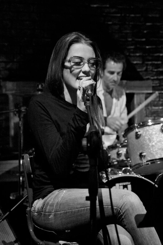 a black and white image of a woman on stage