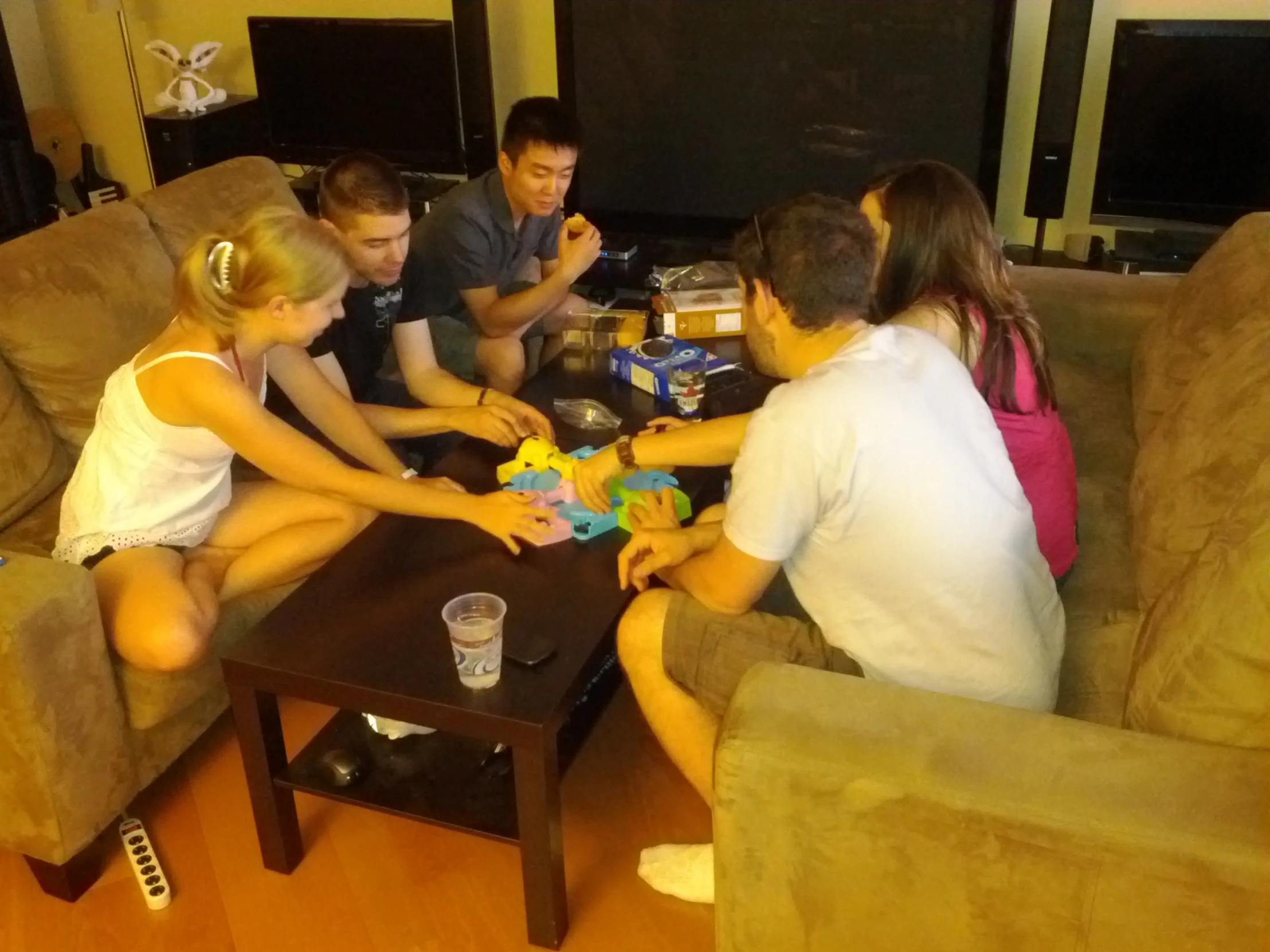 group of people sitting around a coffee table playing games