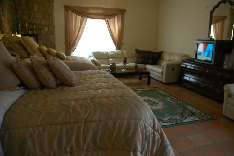 a el room decorated with a tv, couch and windows