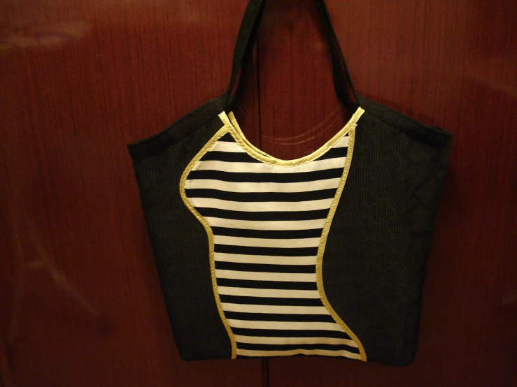 a black and white purse with gold trim
