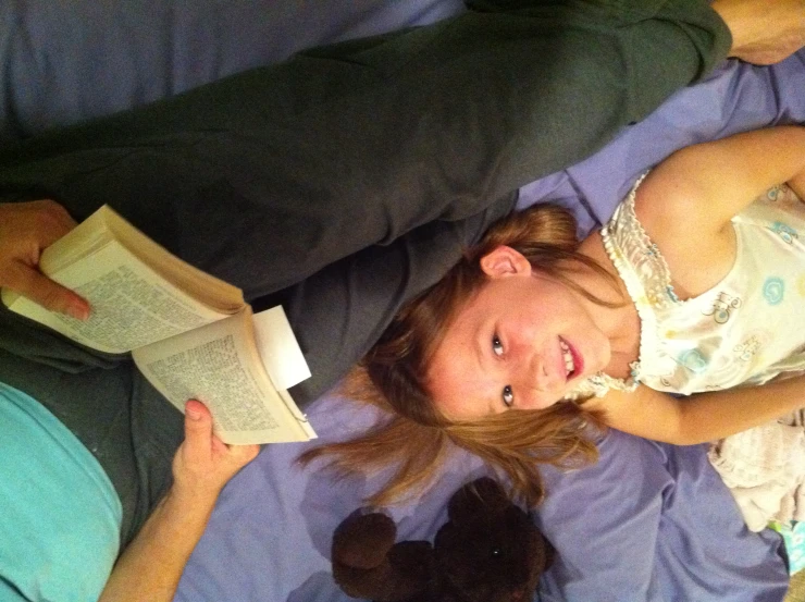 a girl lying down with an open book