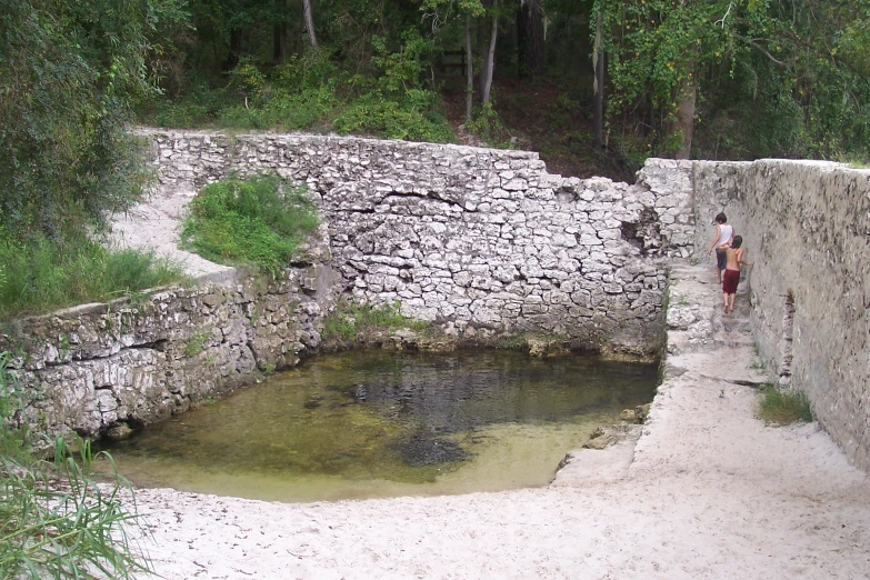 people walking down steps to a small pool