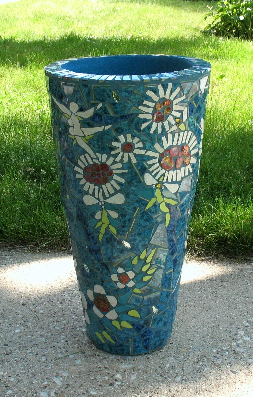 this blue ceramic flower pot is decorated with a large flower and leaves pattern