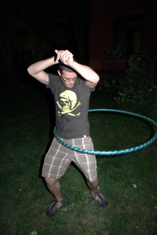 a man stands with his arms up as he hurls a green circular