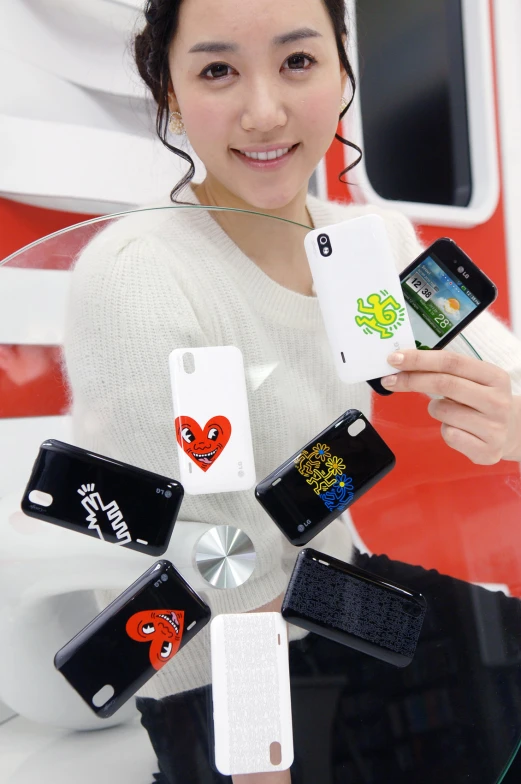 a person holds up a variety of cellphones in their hand