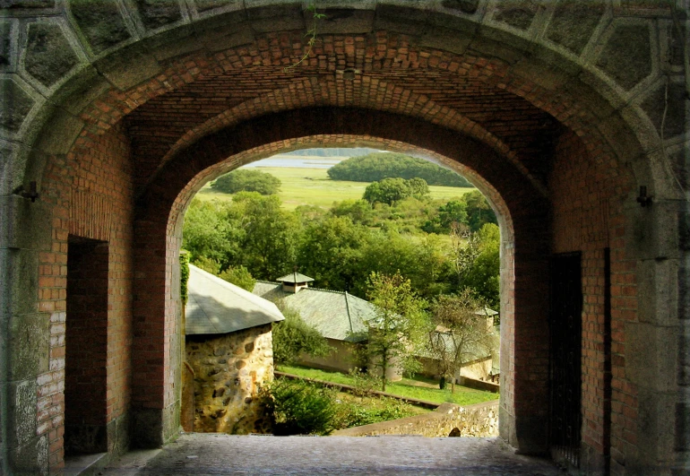 a stone gated entrance into a green field