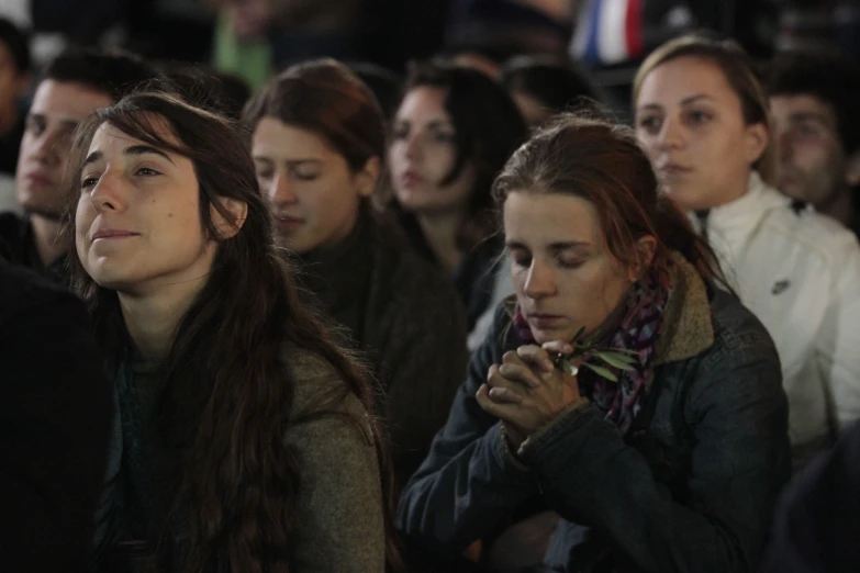 people sitting down and praying together at night