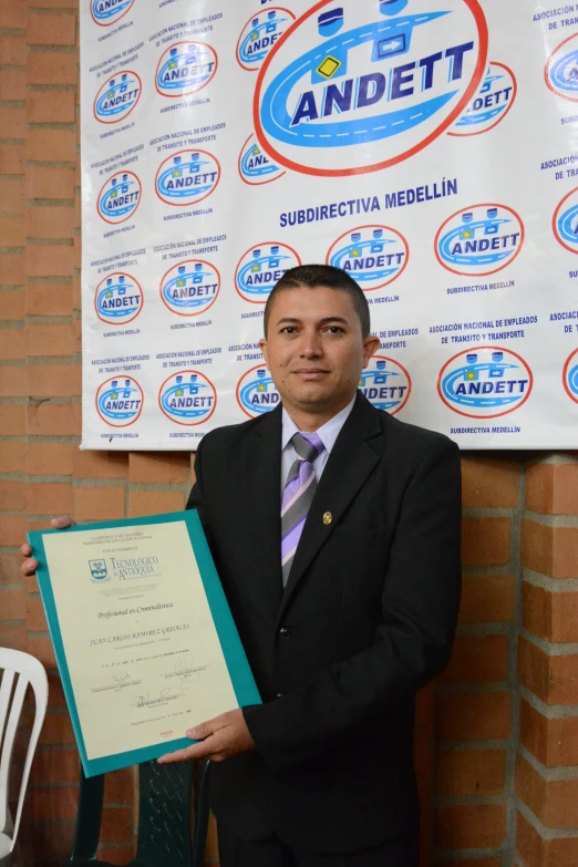 a man in a suit and tie holding up an award