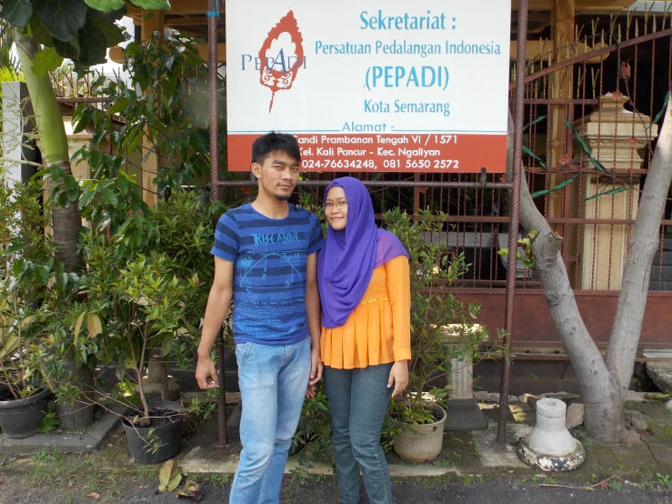 a couple of people standing next to a sign