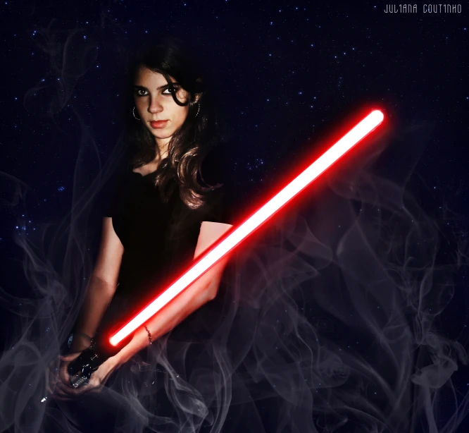 a woman holding a light saber, surrounded by smoke