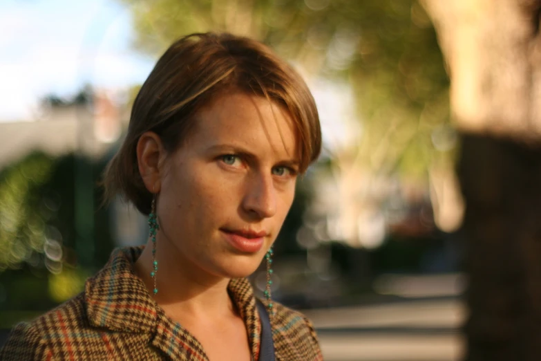 a woman wearing earrings looking at the camera