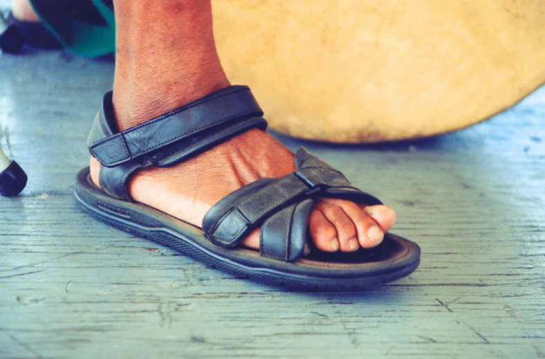 a person with foot sandals and a piece of wood