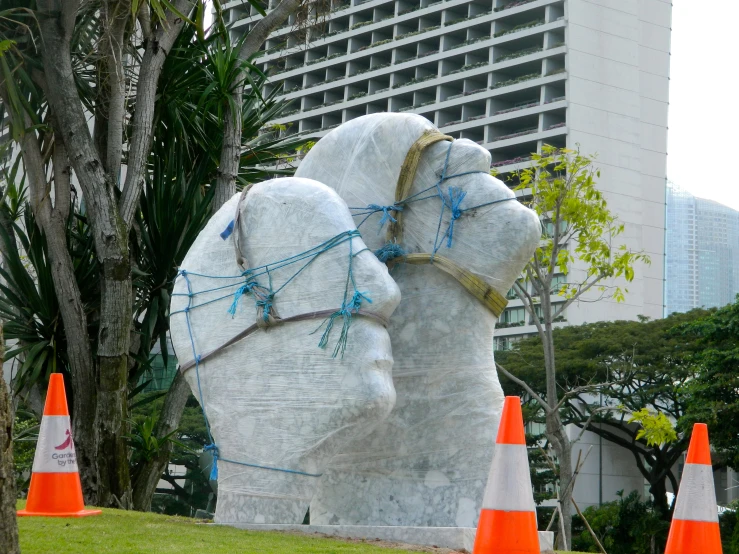 a white sculpture with blue string wrapped around its face