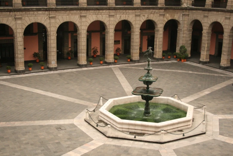 the courtyard of a historical building features stone and arches