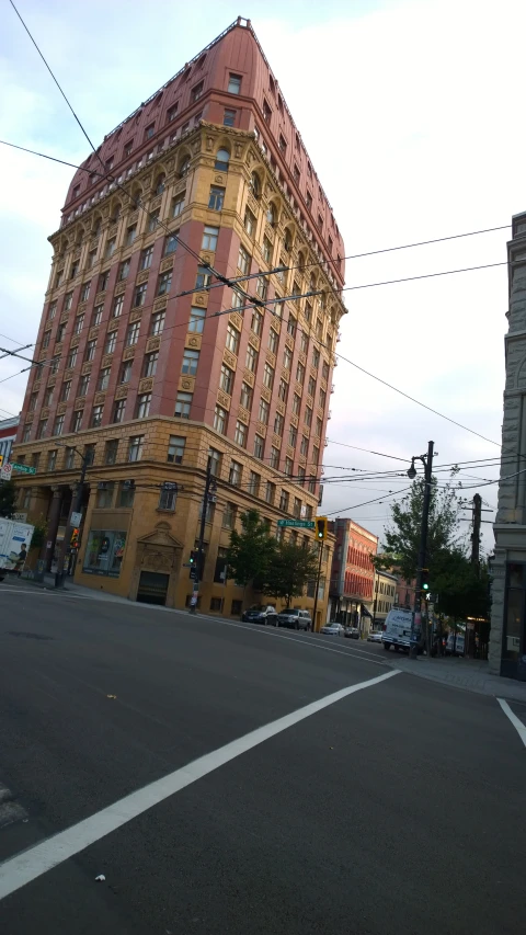 a very tall brown building sitting on the corner of a street