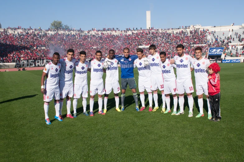 a soccer team poses for a group po on a field