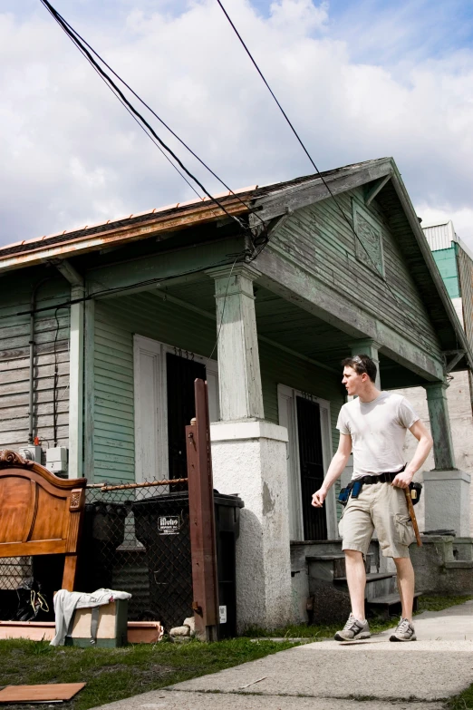 a man in white shirt standing in front of a building