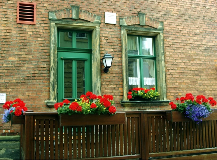 two large windows and brown wooden fence on brick building